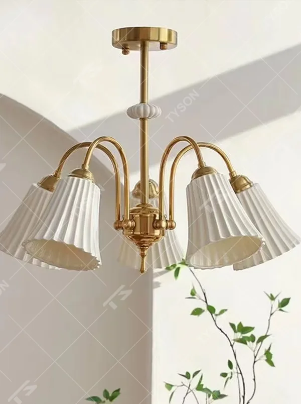 A French retro light luxury style 3-head chandelier, featuring a brass-colored metal frame paired with pleated fabric lampshades. It emits a soft and warm glow when lit, combining decorative appeal with practical illumination, ideal for creating an elegant and romantic space atmosphere.