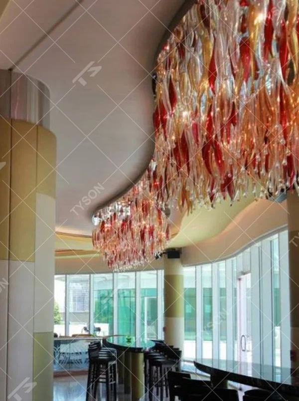 This red-gold gradient liuli leaf art chandelier is made of liuli leaf-shaped ornaments, layered into an arc-shaped drooping shape, with light refracting a colorful halo through it, serving both lighting and installation art purposes, suitable for trendy commercial spaces such as bars and clubs.