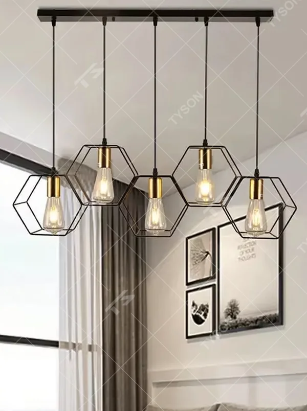 An industrial style 5-head linear chandelier, featuring geometric cage lampshades made of dark brown metal paired with vintage filament bulbs. Its linear arrangement combines decorative appeal with practical illumination, ideal for creating a bold and rugged space atmosphere.