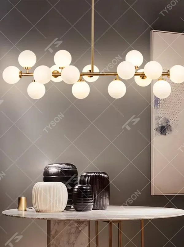 A modern light luxury style linear molecular ball chandelier, featuring a gold metal frame paired with multiple milky white glass glowing spheres of varying sizes, shaped like a star cluster or molecular structure suspended in space. It emits a soft and uniform glow when lit, combining decorative appeal with practical illumination, ideal for creating a minimalist and sophisticated space atmosphere.