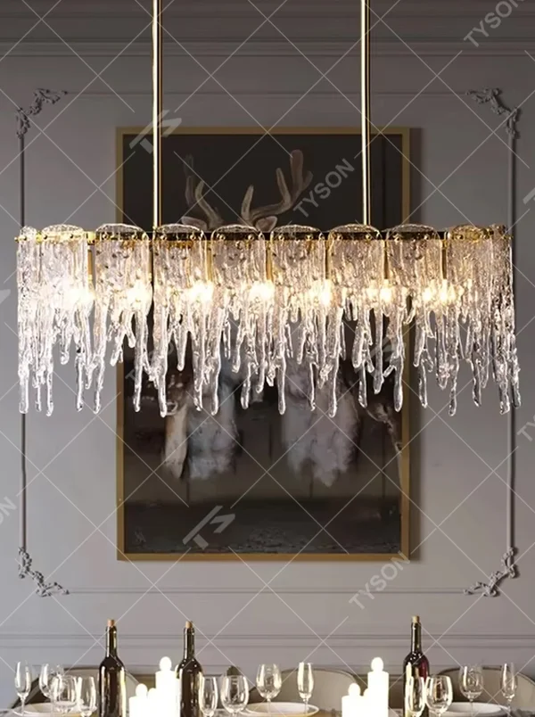 This modern light luxury linear chandelier features a gold metal frame paired with icicle-shaped transparent crystal pendants. Light refracts through the crystals to emit a brilliant and soft glow, serving both lighting and decorative purposes, suitable for modern light luxury spaces such as dining rooms and villa living rooms.