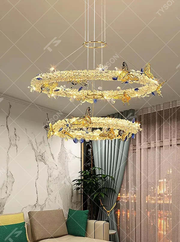 A light luxury and glamorous three-tiered ring chandelier, decorated with crystal gravel, natural blue-veined stone, and gold metal butterflies. Its staggered ring structure resembles flowing cosmic orbits, emitting a brilliant yet soft glow when lit, combining artistic decoration with lighting functionality, ideal for creating a high-end and romantic space atmosphere.