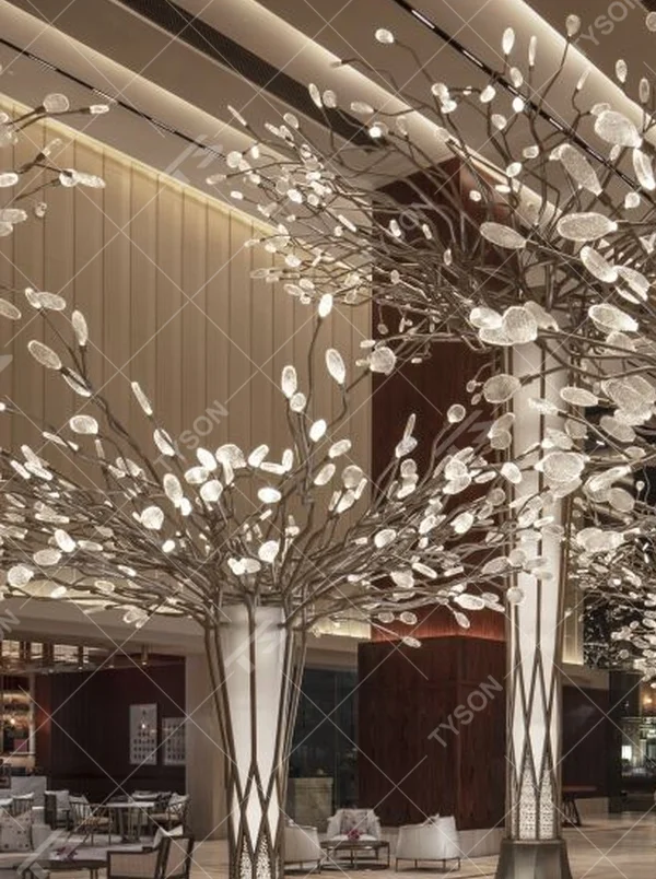 This new Chinese artistic tree-shaped chandelier features a metal branch frame paired with transparent light-emitting leaf-shaped ornaments, presenting a visual effect of blooming flower trees, serving both lighting and decorative purposes, suitable for large spaces such as hotel lobbies and high-end clubs.