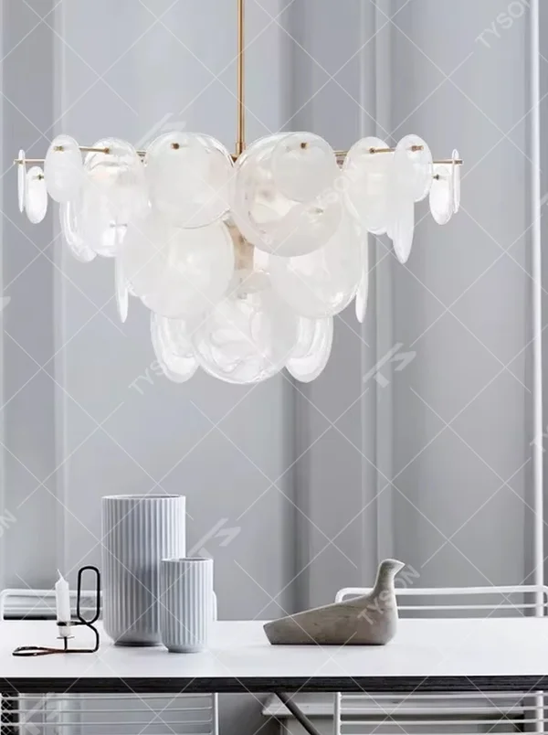 French light luxury glass cloud chandelier, with a golden metal frame paired with transparent glass sheets stacked into a fluffy cloud shape, featuring soft and transparent light, combining decorative and lighting functions, suitable for bedrooms, living rooms, light luxury style spaces.