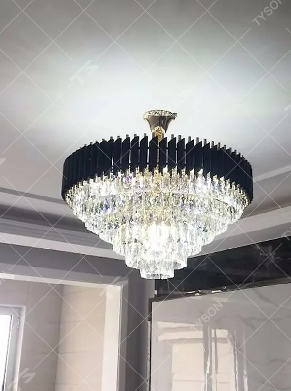 Modern light luxury rectangular crystal chandelier, with a black and gold metal frame on the upper layer and full-length transparent crystal strips hanging below, featuring bright and soft light, combining decorative and lighting functions, suitable for large living rooms, high-end dining rooms, villas, clubs and other spaces.
