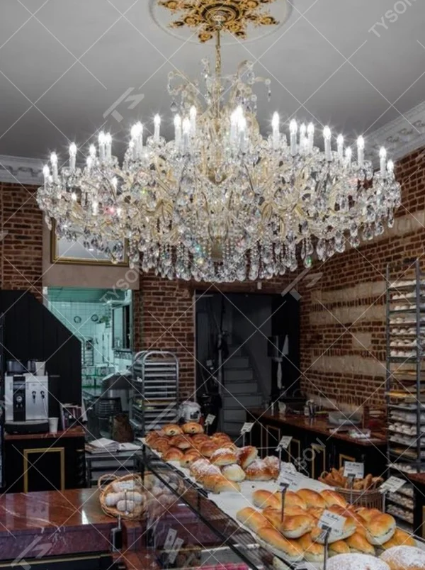 This European court-style multi-layer crystal chandelier features a gold metal frame, paired with faceted crystals and candle-style lamp heads, with light refracting a brilliant halo through the crystals, serving both lighting and decorative purposes, suitable for luxury spaces such as high-end restaurants and clubs.