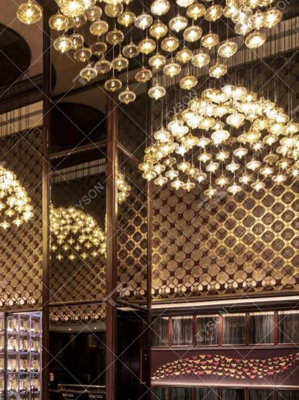 This light luxury bubble cloud chandelier is composed of a large number of transparent glass bubble lamp heads, arranged in a hemispherical staggered manner. Warm light refracts through the bubbles to emit soft and brilliant light spots, serving both lighting and decorative purposes, suitable for high-end restaurants, clubs and other light luxury style spaces.