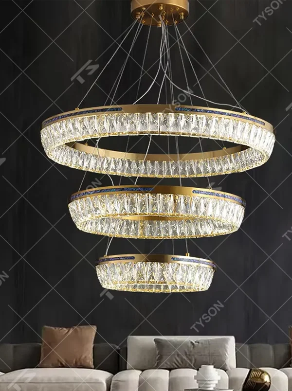 Modern light luxury three-layer ring crystal chandelier, with golden metal frames and transparent crystal lampshades, the staggered suspended shape combines decorative and lighting functions, suitable for high-ceiling living rooms, villas, high-end clubs and other spaces.