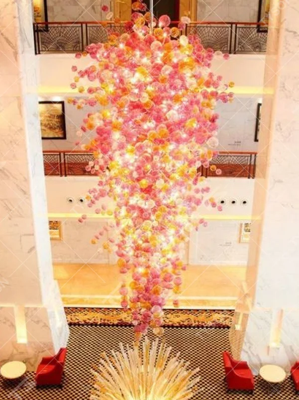 Modern artistic flower cluster-shaped hanging chandelier, with pink-orange gradient crystal/acrylic petals stacked into a full flower cluster shape, combining artistic decoration and main lighting functions, suitable for high-ceiling large-scale spaces such as hotel lobbies, high-end clubs, and commercial atriums.
