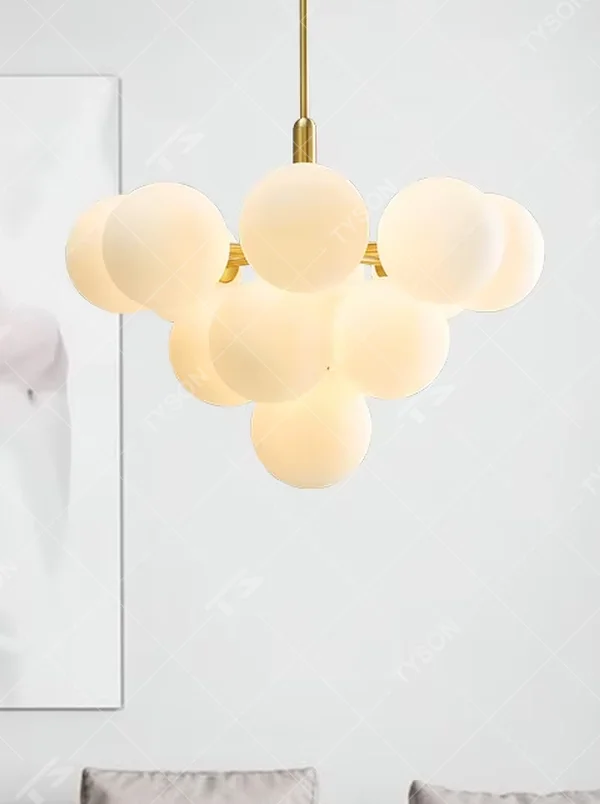 Modern healing cloud magic bean chandelier, featuring a brass metal frame paired with fluffy milk-white frosted glass balls to form a cloud shape. It emits soft and gentle light, combining a dreamy feel and cozy ambiance, making it a decorative lighting fixture that enhances the warmth of the space.