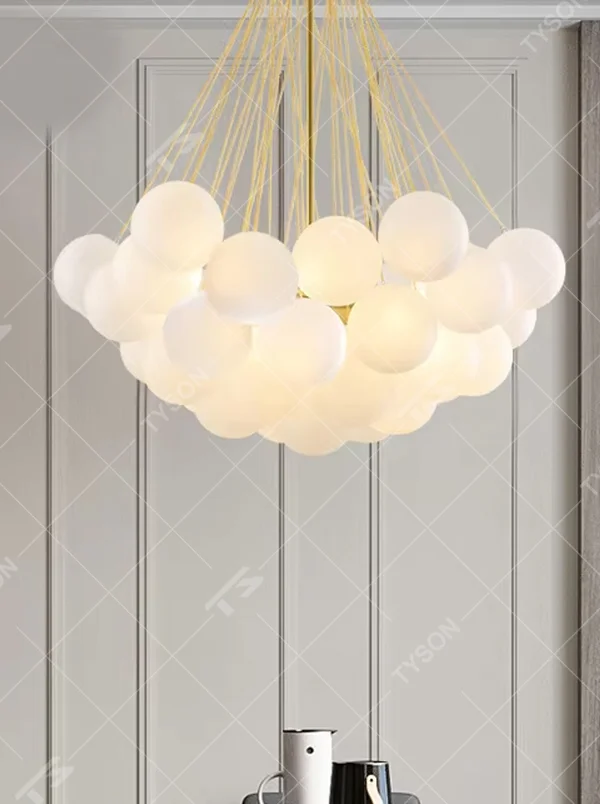 Modern healing cloud chandelier, featuring a radial suspension wire structure in black metal paired with fluffy milk-white frosted glass balls to form a cloud shape. It emits soft and gentle light, combining a dreamy feel and cozy ambiance, making it a decorative lighting fixture that enhances the warmth of the space.