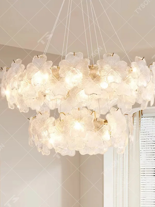 This modern light luxury two-layer petal chandelier is suspended by white cords, composed of two layers of transparent glass petals arranged in a staggered layout with delicate textures. When lit, it emits a soft and gentle glow, combining a romantic ambiance with an ethereal feel. Ideal for living rooms, bedrooms, dining rooms, and other spaces, it adds a dreamy and exquisite touch to modern minimalist or French light luxury home environments.