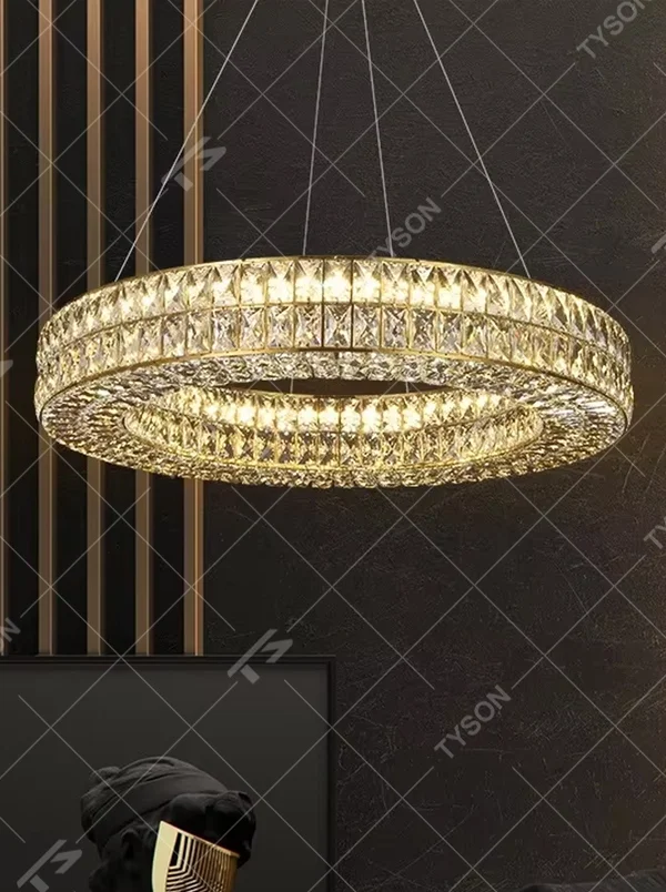 This modern light luxury linear crystal chandelier features a gold metal frame, inlaid with two layers of cut crystal blocks to form a square shape. When lit, light refracts through the crystals to emit a brilliant and luxurious glow, combining an exquisite texture with an ambient atmosphere. Ideal for dining rooms, bars, light luxury apartments, and other spaces, it adds an exquisite and sophisticated touch to modern minimalist or light luxury home environments.
