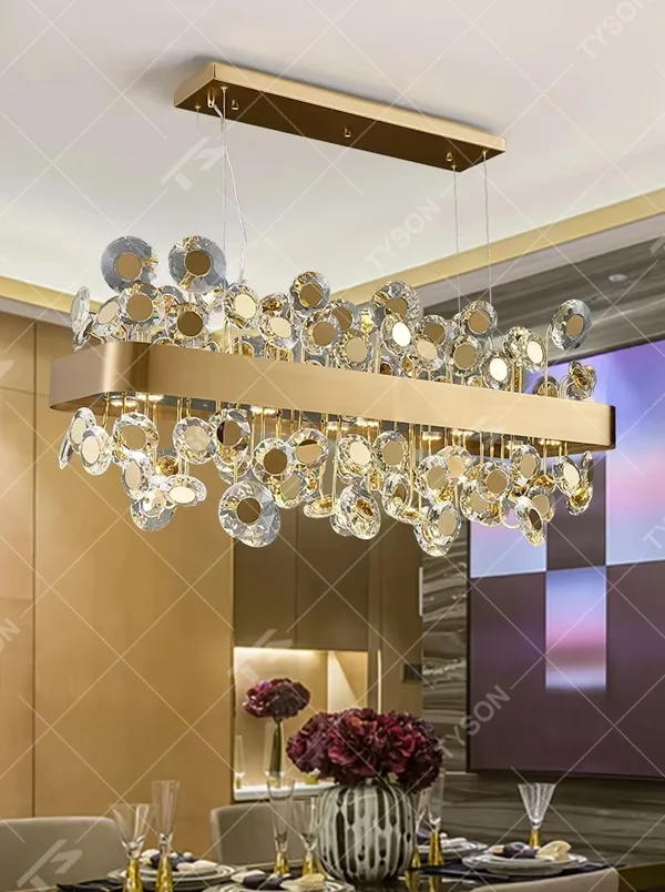 This modern light luxury rectangular crystal chandelier features a gold metal frame inlaid with multiple layers of circular-cut crystals and gold reflective discs. The staggered crystals create a brilliant and luxurious light effect when illuminated, combining decorative appeal with an ambient atmosphere. Ideal for dining rooms, bars, and above dining tables in light luxury apartments, it adds an elegant and exquisite touch to modern light luxury or European-style luxury spaces.
