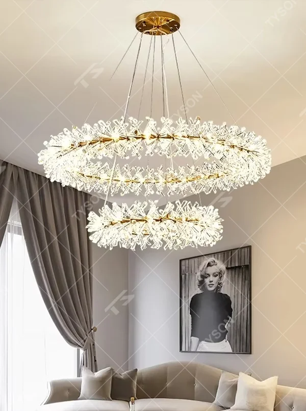 This modern light luxury multi-layer circular chandelier features a gold metal frame, inlaid with transparent snowflake-shaped crystal modules, combined into a three-layer staggered circular shape. When lit, light refracts through the crystal to emit a brilliant and soft glow, combining an ethereal feel with an ambient atmosphere. Ideal for living rooms, dining rooms, light luxury apartments, and other spaces, it adds a dreamy and exquisite touch to modern minimalist or French light luxury home environments.