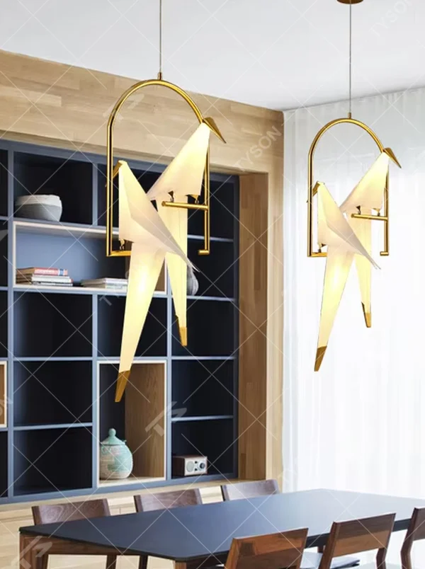 Modern art origami crane cage chandelier, featuring an arched gold metal frame paired with a white origami crane lampshade made with paper folding techniques. Its elegant and dynamic lines combine artistry and ambiance, making it a decorative lighting fixture that elevates the space's style.