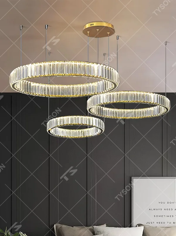 This modern light luxury multi-layer circular crystal chandelier features gold metal frames, inlaid with transparent long crystals to create three groups of staggered circular shapes. When lit, light refracts through the crystals to emit a brilliant and soft glow, combining a layered texture with an ambient atmosphere. Ideal for high-ceiling living rooms, duplex apartments, light luxury apartments, and other spaces, it adds an exquisite and sophisticated touch to modern minimalist or light luxury home environments.