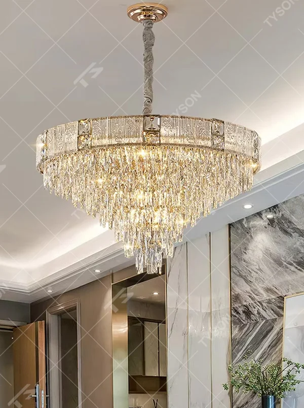 This light luxury and grand multi-layer conical crystal chandelier features a gold metal frame, with vertical-textured glass lampshades on the upper layer and multiple layers of transparent crystal tassels hanging below, creating a full conical shape. When lit, light refracts through the crystal to emit a brilliant and luxurious glow, combining elegant texture with an ambient atmosphere. Ideal for living rooms, dining rooms, villa high-ceiling spaces, and other areas, it adds an elegant and exquisite touch to European light luxury or modern luxury home environments.