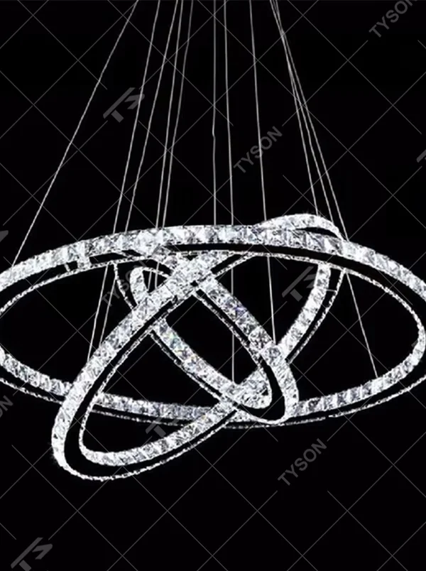 This modern light luxury interwoven ring crystal chandelier consists of transparent crystal rings of varying sizes interlaced and nested, suspended by silver cords. When lit, light refracts through the crystal to emit a brilliant and dynamic glow, combining a futuristic feel with an ambient atmosphere. Ideal for high-ceiling living rooms, villa foyers, light luxury apartments, and other spaces, it adds an exquisite and sophisticated touch to modern minimalist or light luxury environments.