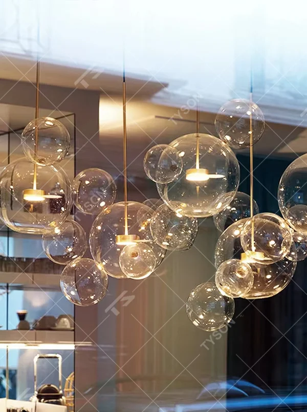 Modern art bubble cluster chandelier, featuring a cloud-like arrangement of transparent glass bubbles paired with black and gold suspension wires. Light refracts through the bubbles to create a soft and translucent glow, combining a dreamy feel and artistic ambiance, making it a high-end decorative lighting fixture that elevates the space's style.