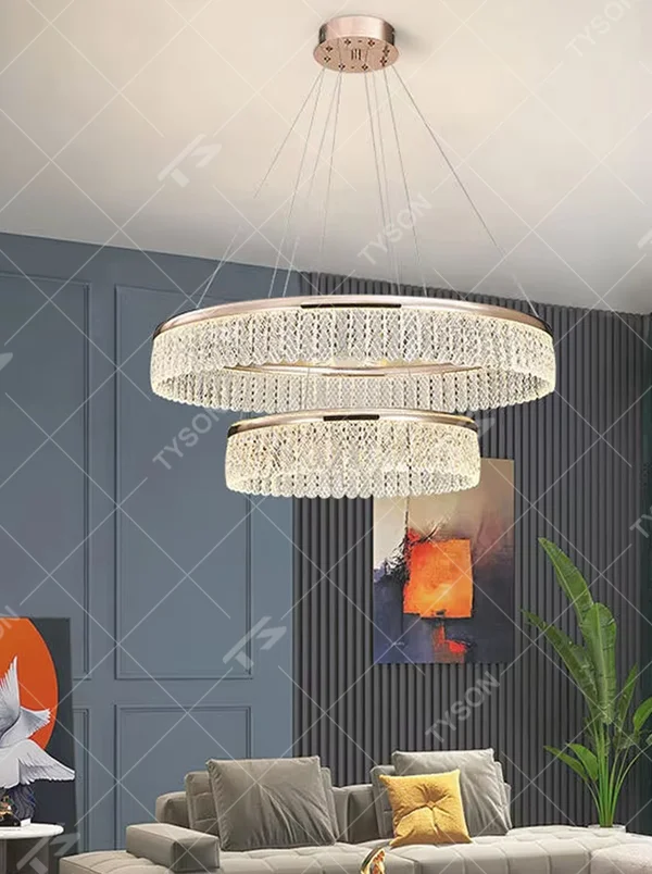 Modern light luxury double-layer ring crystal chandelier, featuring a rose gold metal frame paired with dense crystal strips to create a double-layer suspended shape. Light refracts through the crystals to produce a brilliant and soft glow, combining sophistication and ambiance, making it a high-end decorative lighting fixture that elevates the space's style.