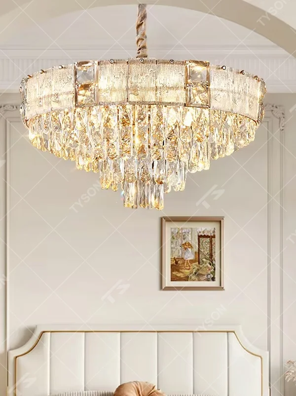 This light luxury and grand two-layer crystal chandelier features a gold metal frame with vertical-textured glass lampshades on the upper layer, and multiple layers of transparent crystal tassels hanging below, creating a full dome shape. When lit, light refracts through the crystal to emit a brilliant and soft glow, combining elegant texture with an ambient atmosphere. Ideal for bedrooms, living rooms, dining rooms, and other spaces, it adds an elegant and exquisite touch to European light luxury or modern minimalist home environments.
