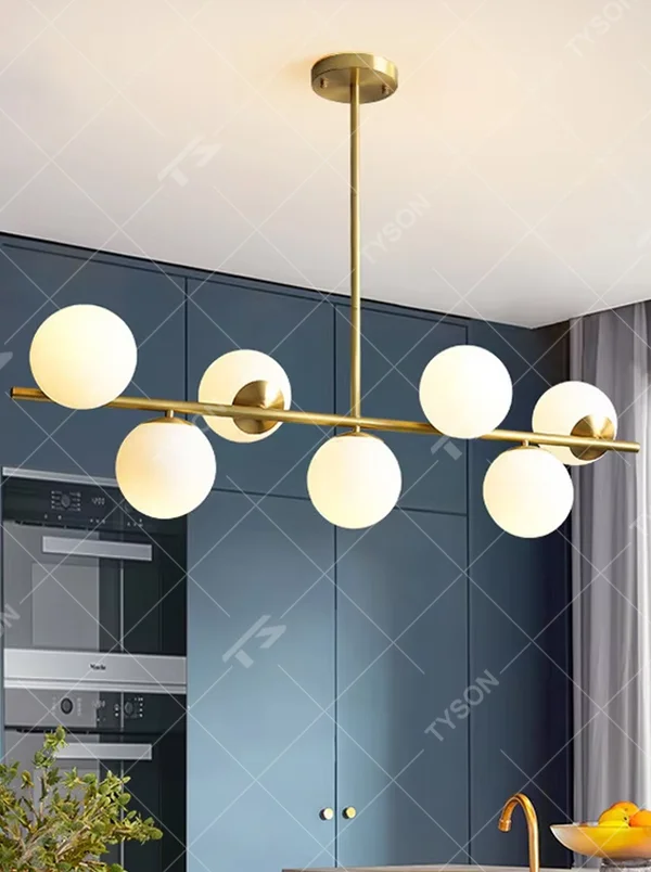 This modern minimalist linear magic bean chandelier features a gold metal frame and multiple milky white frosted glass ball lampshades, arranged in a staggered layout. When lit, it emits soft and even light, combining minimalist design with a gentle ambient atmosphere. Ideal for dining rooms, bars, kitchen islands, and other spaces, it adds an exquisite and soft touch to modern minimalist or Nordic-style home environments.