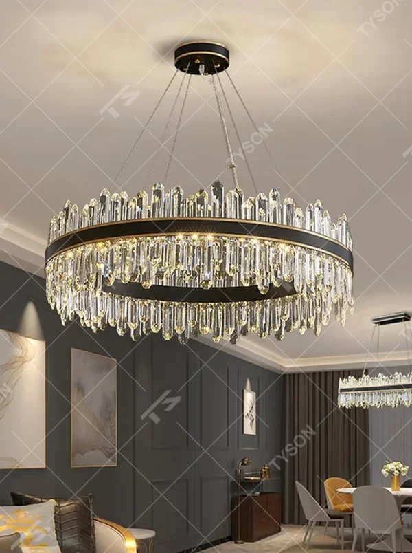 This modern light luxury two-layer circular crystal chandelier features a black-gold metal frame, with dense transparent long crystals hanging down to form a full circular shape. When lit, light refracts through the crystal to emit a brilliant and luxurious glow, combining a bold texture with an ambient atmosphere. Ideal for living rooms, dining rooms, light luxury apartments, and other spaces, it adds an exquisite and sophisticated touch to modern minimalist or light luxury home environments.