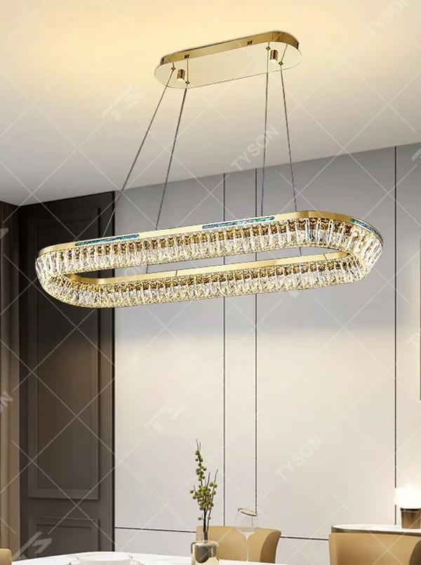 This modern light luxury rectangular two-layer crystal chandelier features a gold metal frame, inlaid with transparent long crystals to form a double-layered rectangular shape. When lit, light refracts through the crystal to emit a brilliant and soft glow, combining an exquisite texture with an ambient atmosphere. Ideal for dining rooms, bars, and above dining tables in light luxury apartments, it adds an exquisite and sophisticated touch to modern minimalist or light luxury spaces.