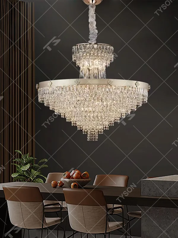 This European luxury two-layer conical crystal chandelier features a champagne gold metal frame, with dense long crystals hanging down to form a two-layer conical layered shape, suspended by a braided cord. When lit, light refracts through the crystals to emit a brilliant and luxurious glow, combining a luxurious texture with an ambient atmosphere. Ideal for villa living rooms, luxury dining rooms, high-end clubs, and other spaces, it adds an elegant and exquisite touch to European luxury or modern light luxury environments.