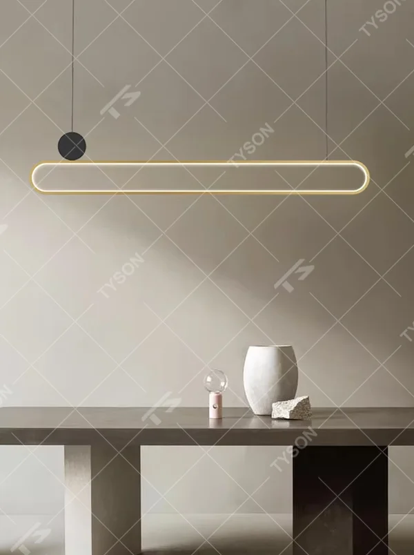 Modern light luxury black and gold linear chandelier, featuring a gold metal frame paired with a white luminous lamp body, accented with a black balancing ball on the side. Its clean and elegant lines combine style and ambiance, making it a modern home lighting fixture that enhances the space's texture.
