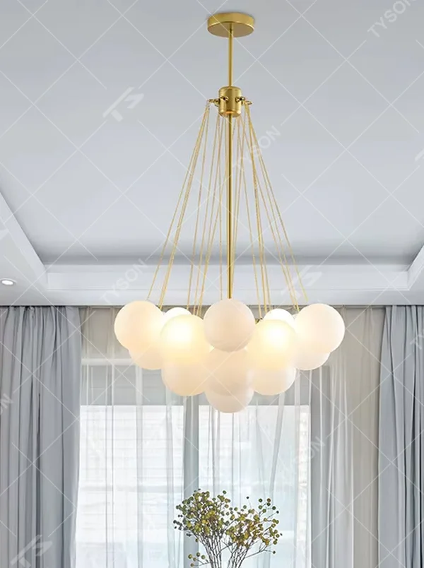 This modern light luxury milk-white cluster chandelier features a gold metal frame, paired with multiple milky white frosted glass ball lampshades arranged in a cloud-like staggered layout. When lit, it emits a soft and gentle glow, combining romantic ambiance with design appeal. Ideal for living rooms, dining rooms, bedrooms, and other spaces, it adds a warm and exquisite touch to modern light luxury, Nordic, or minimalist home environments.