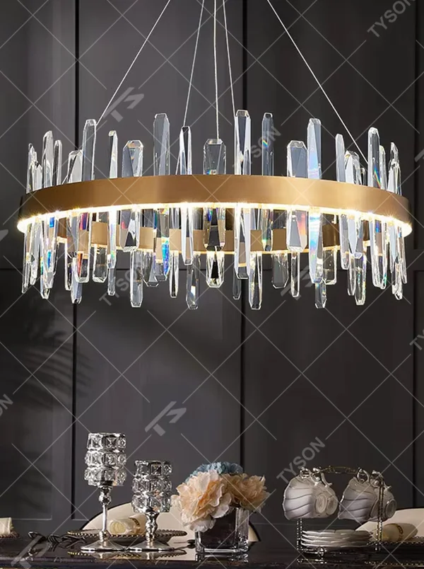 This modern light luxury circular crystal chandelier features a gold metal frame, with transparent crystal strips of varying lengths hanging down to form a staggered circular shape. When lit, light refracts through the crystal to emit a brilliant and dynamic glow, combining an exquisite texture with an ambient atmosphere. Ideal for dining rooms, living rooms, light luxury apartments, and other spaces, it adds an exquisite and sophisticated touch to modern minimalist or light luxury home environments.