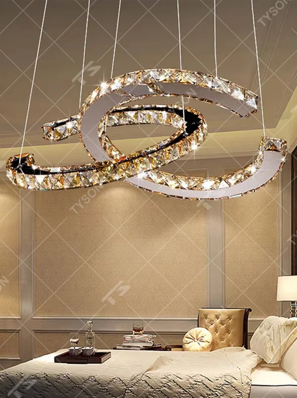 This modern light luxury interwoven ring crystal chandelier consists of multiple crystal-embedded metal rings interlaced and nested, suspended by silver cords. When lit, light refracts through the crystal to emit a brilliant and dynamic glow, combining a futuristic feel with an ambient atmosphere. Ideal for bedrooms, living rooms, light luxury apartments, and other spaces, it adds an exquisite and sophisticated touch to modern minimalist or light luxury home environments.
